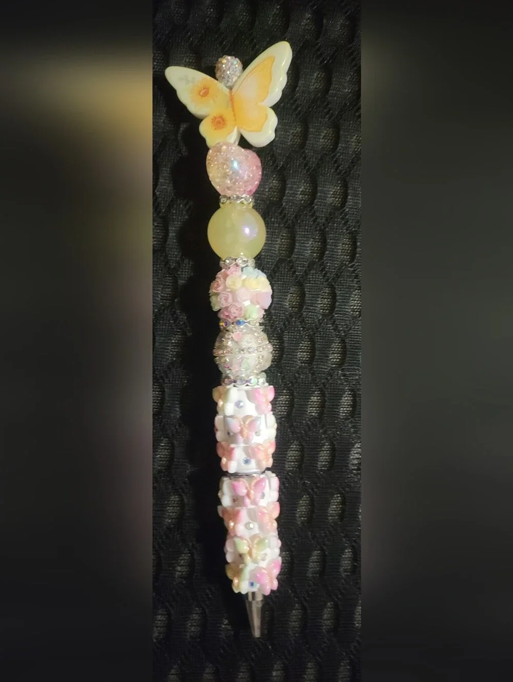 Handmade beaded ballpoint pen decorated with a pastel butterfly and floral theme